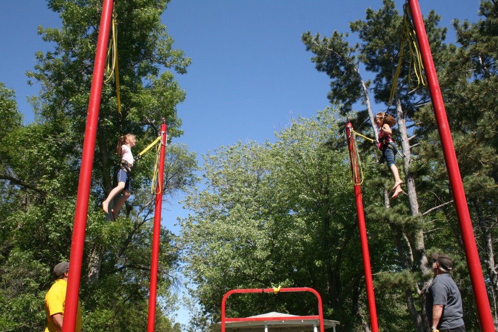 Sofia Losure, left, and Maddie Sumption, right, enjoy the bungie trampoline during Finn Fest in Frederick, June 15, 2013.